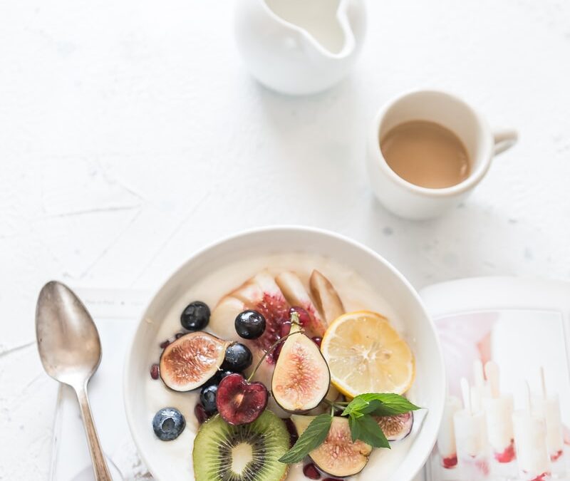 white ceramic plate beside gray steel spoon