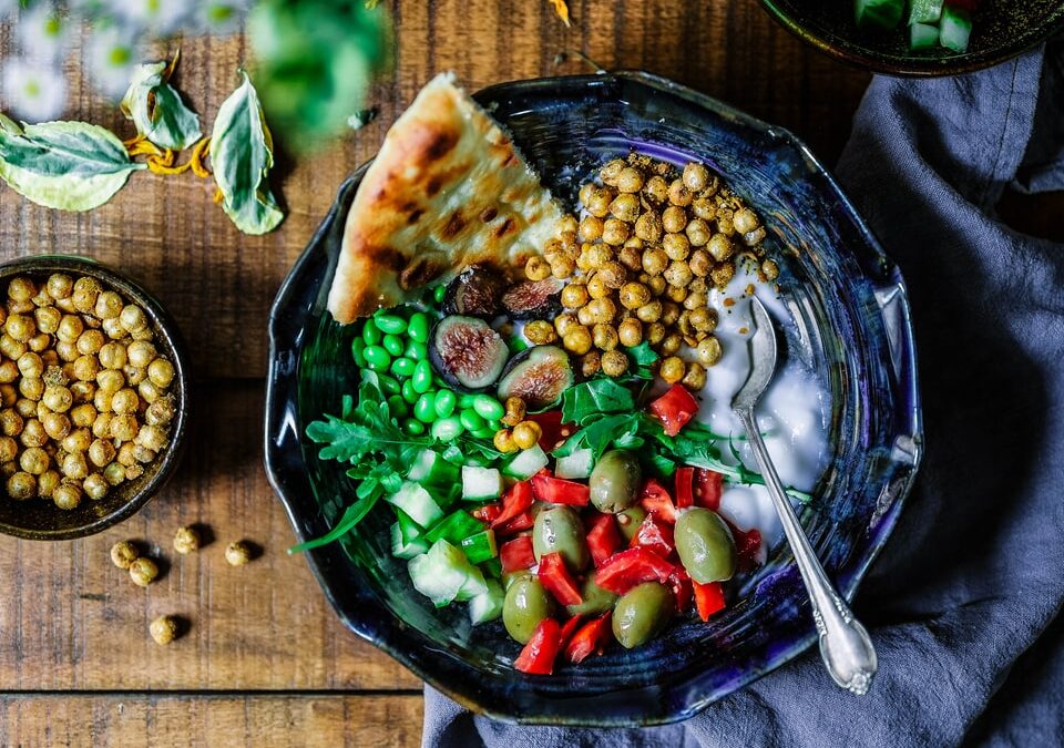 silver spoon on black ceramic bowl with vegetables