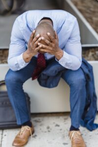 Upset faceless black businessman on street