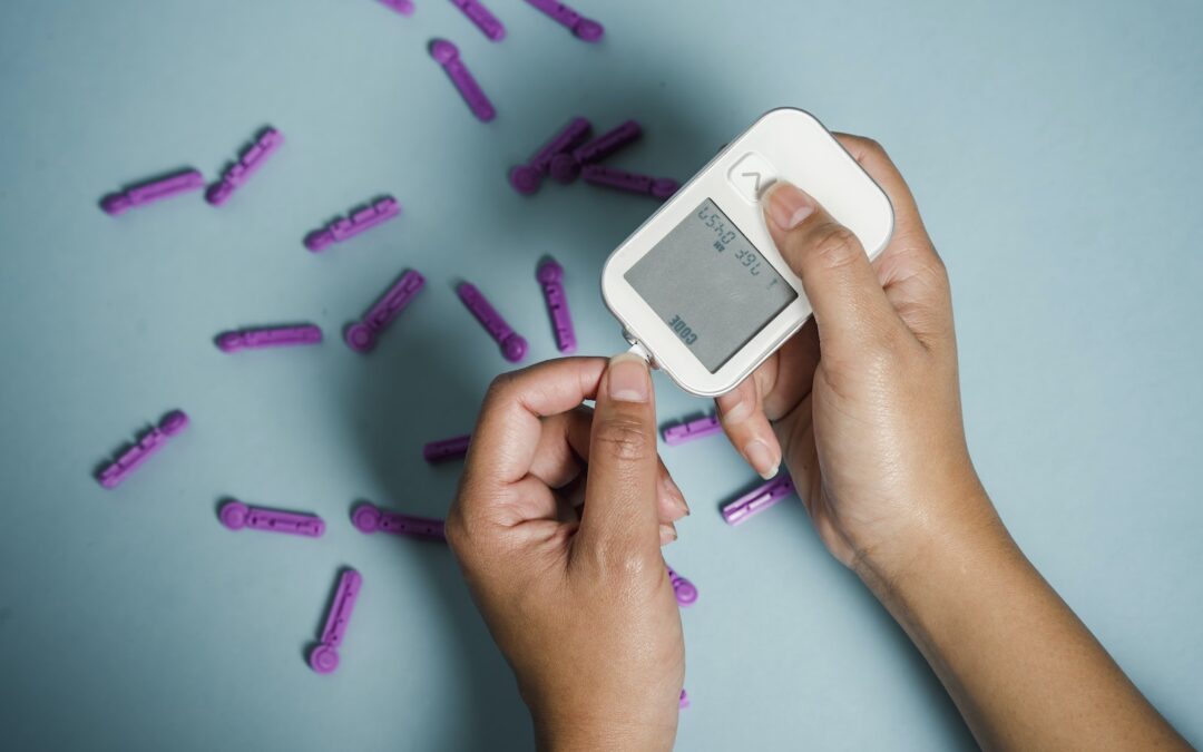Top view of crop anonymous female diabetic measuring blood sugar with glucometer over scattered lancets